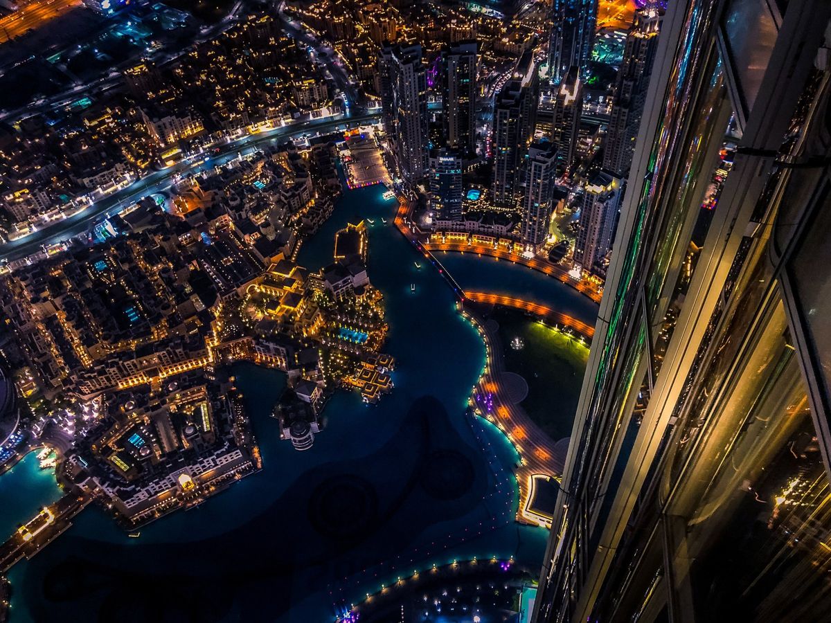 Blick von oben auf das nächtliche Downtown Dubai mit dem Burj-Khalifa-See